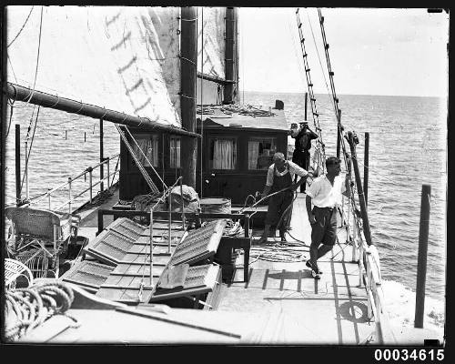 Three men on the deck of a schooner at sea