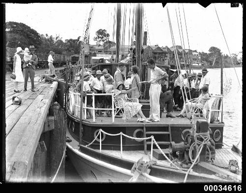 A sailing vessel with people on board, berthed near Maryborough Rowing Club