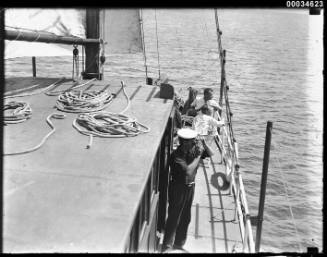 Three men on the deck of a sailing vessel