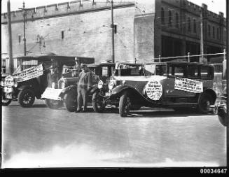 Four men posing near cars at a Movietone event