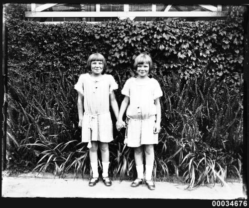 Two young girls holding hands