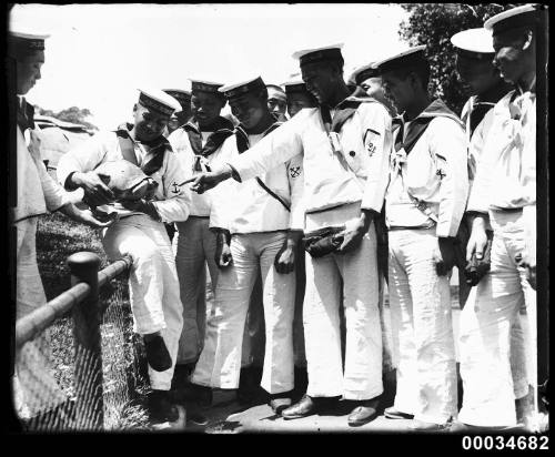 Japanese sailors from the Imperial Japanese Naval Squadron handle a turtle at Taronga Zoo