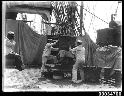 Japanese sailors with a coal basket probably on board naval vessel TAISEI MARU