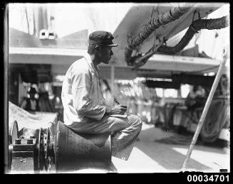 Japanese sailor sitting on a winch probably on board naval vessel TAISEI MARU