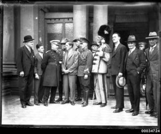 Group portrait of men in uniform and civilian dress possibly at the entrance Town Hall in Sydney