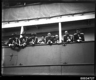 Uniformed men possibly from a military band and leaning over the ship WELLINGTON