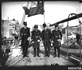 Three Chilean Navy officers and the Consul General for Chile on the deck of the GENERAL BAQUEDANO