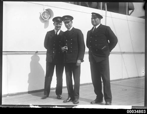 Three officers on the deck of a ship