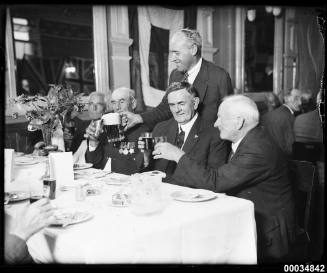 Retired military personnel at a table drinking beer