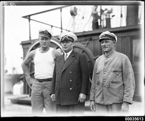 Captain Lorenz Peters with crew members near the ship's wheel on MAGDALENE VINNEN