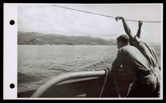 A16747 Major M.Gratton, AIF, from Adelaide, and Lieutenant R. Milne, RANVR, from Adelaide, watching the picturesque coast at Namlea, Boeroe, from HMAS GLENELG