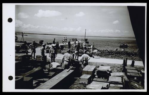 A16782 Japanese soldiers, supervised by personnel from HMAS GLENELG, unload supplies at Ceram for the Netherlands Indies Civil Administration