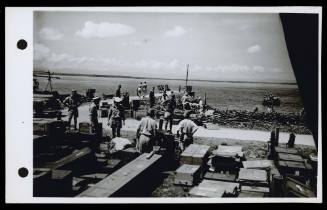 A16782 Japanese soldiers, supervised by personnel from HMAS GLENELG, unload supplies at Ceram for the Netherlands Indies Civil Administration