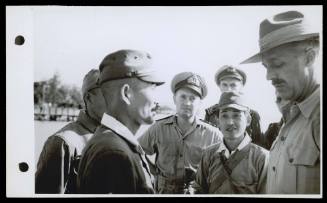 A16752 Major Arnott, Australian Army Intelligence Officer (right) and Lieutenent Commander Whitebrook, Captain of HMAS GLENELG, interrogating Japanese officers at Ceram. October 1945