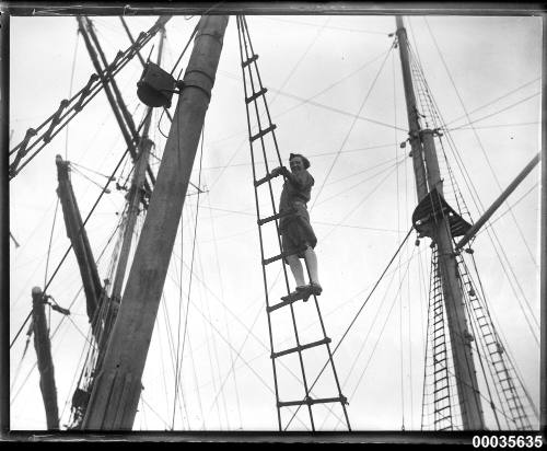 Young woman standing on shrouds on board a ship