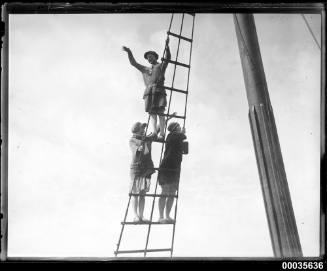 Three women standing on shrouds on board a ship