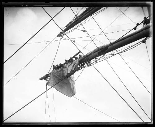 Sailors on spar attending furled sails probably on board the German barque GUSTAV