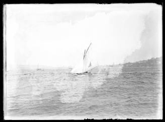 Possibly a 12'foot skiff carrying a triangular sail insignia sailing on harbour possibly near Balmain, Sydney Harbour