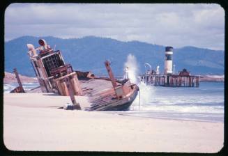 Valerie Taylor standing on a ferry wrecked at Trial Bay, New South Wales during a storm