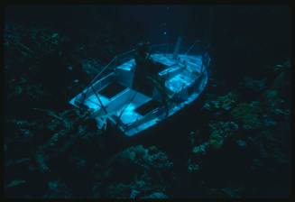 Diver on wreck of small boat underwater