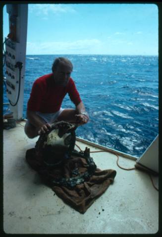 Man with a porthole window and frame from shipwreck