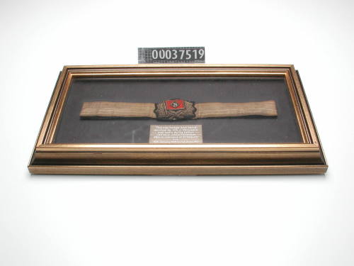 UNIFORM CAP BADGE FOR HOWARD SMITH LINE, WORN BY CAPTAIN JOHN PATERSON ON SS "PERIOD" FROM THE 14th JANUARY 1909 TO THE 2nd JUNE 1910, FRAMED WITH BRASS PLAQUE EXPLAINING PROVENANCE OF BADGE