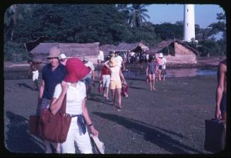 Group of people walking away from huts