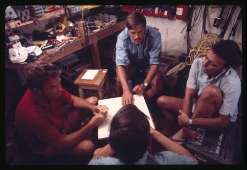 Ron Taylor and three other men around a small white table