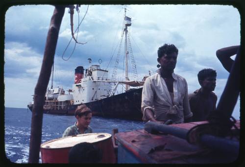 Four  people on a vessel with TERRIER VIII in background