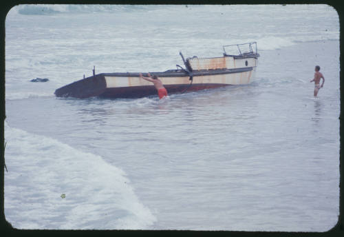 Two men and boat stranded boat at beach