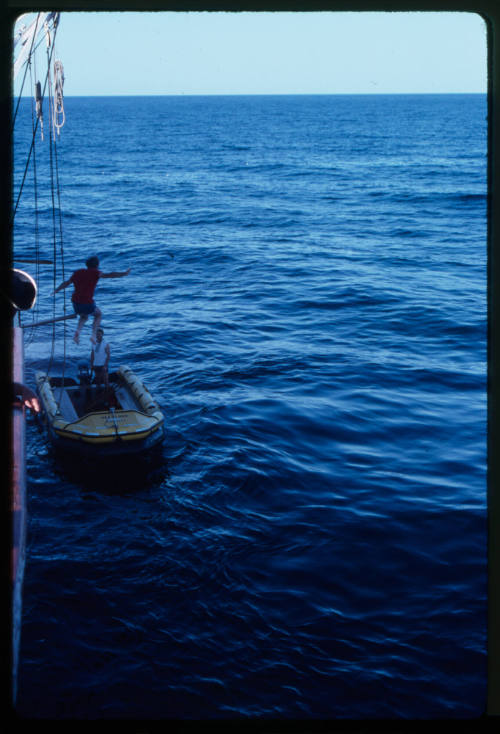 Man jumping into inflatable motor boat