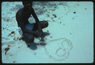 Man with drawn symbol on sand