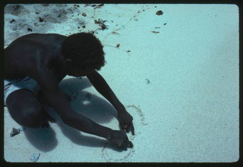 Man drawing two circles in the sand