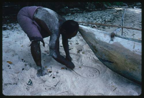 Man drawing symbol on sand