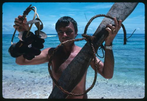 Ron Taylor holding up shark calling equipment