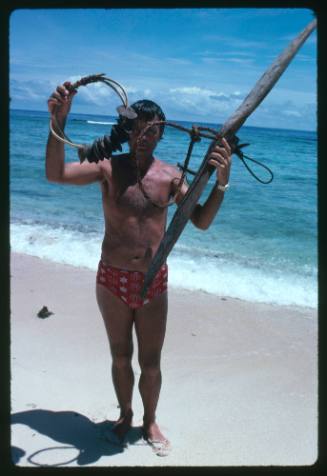 Ron Taylor holding up shark calling equipment