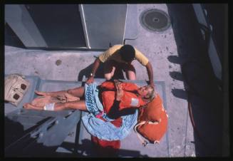 Valerie Taylor lying down on board a vessel after being attacked by a shark