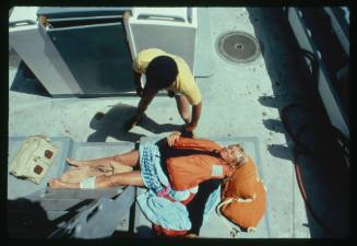 Valerie Taylor lying down on board a vessel after being attacked by a shark