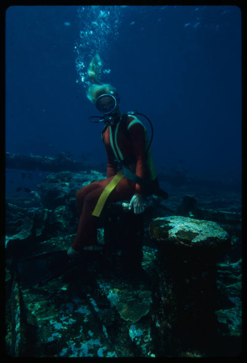 Valerie Taylor sitting on the wreck of Cooma underwater