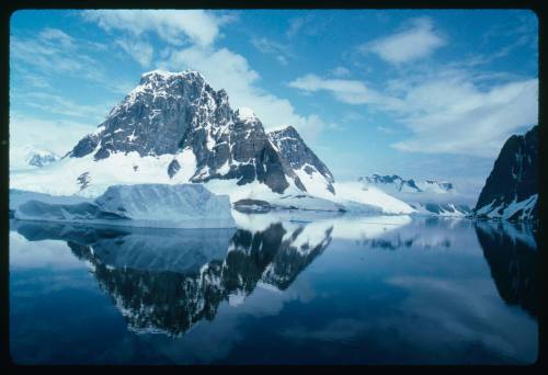 Mountains partially covered in snow across the water