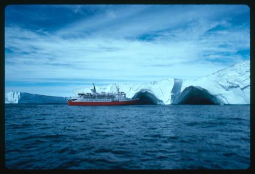 Vessel in the water near ice shelf with arches