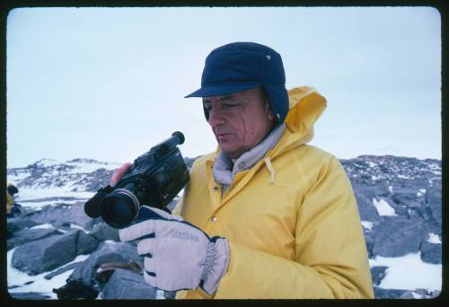 Ron Taylor looking at a camera in his right hand