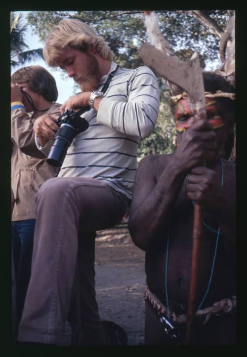 Two men with cameras and an indigenous person