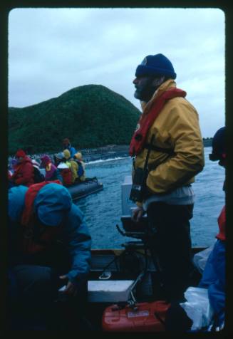 Man standing at the stern of a motorboat