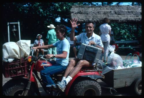 Ron Taylor on the back of a red three wheeled motorcycle