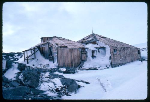 Wooden buildings partially covered in snow