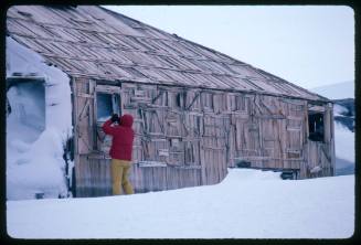 Person at the window of a wooden building