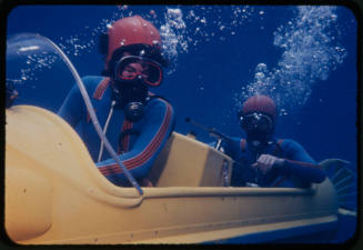 Two people driving an underwater vehicle