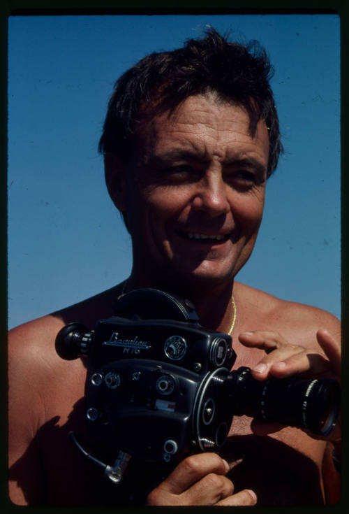 Ron Taylor smiling while holding a camera