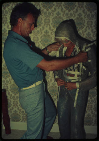 Ron Taylor assisting Valerie Taylor with mesh suit